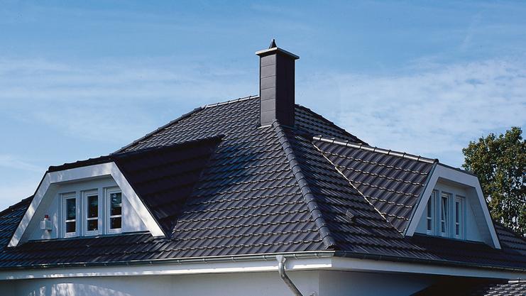 Ein modernes, einheitlich weißes Einfamilienhaus mit Satteldach, Vorgarten und gepflasterter Auffahrt.